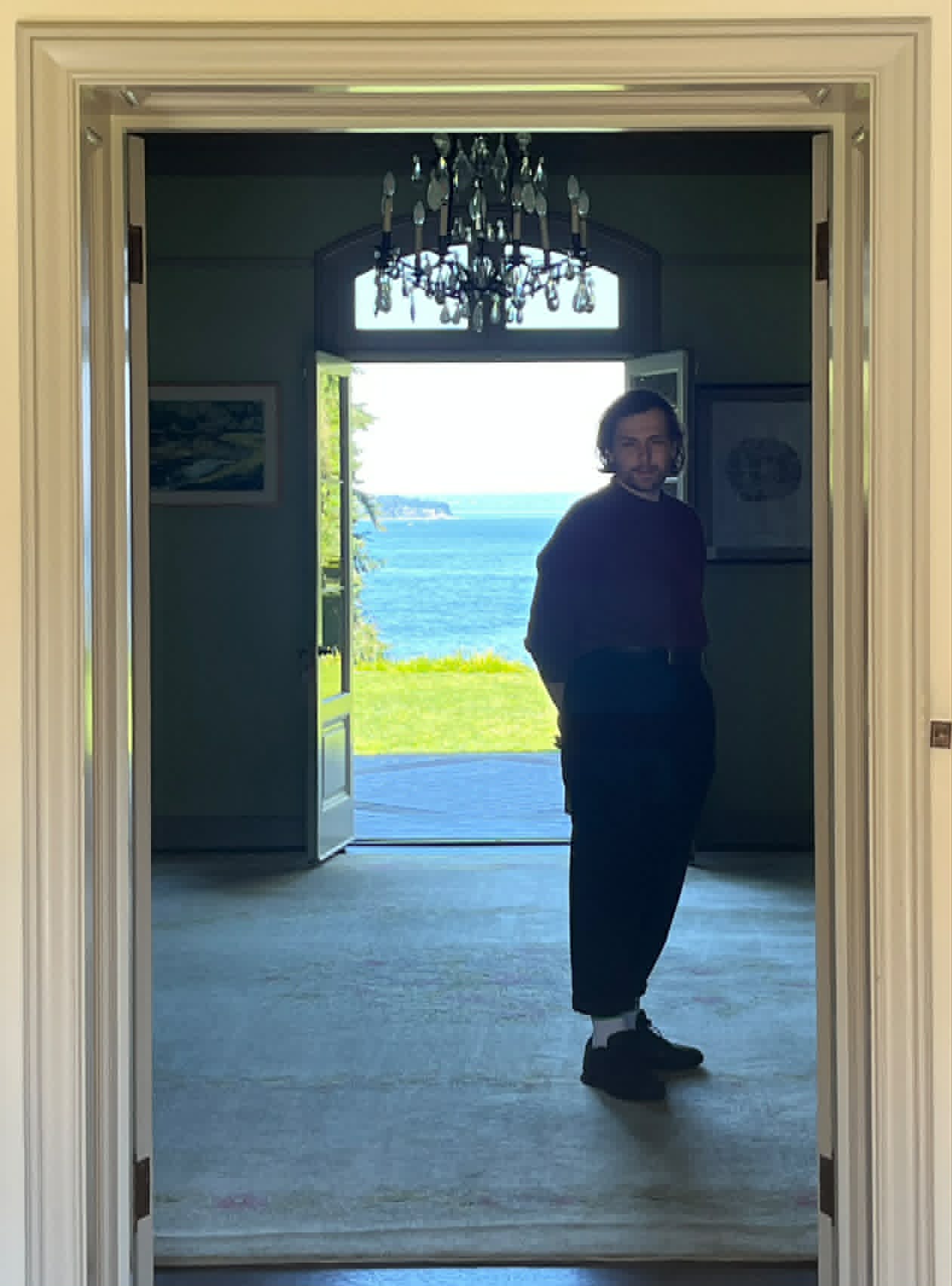 Stephen de Filippo standing in a doorway overlooking the water.